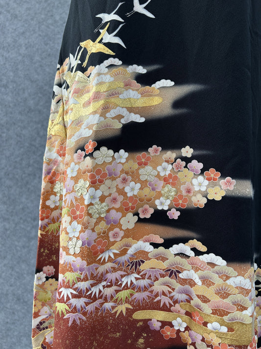 Detail of plum blossoms, pine and flying cranes on black kimono silk
