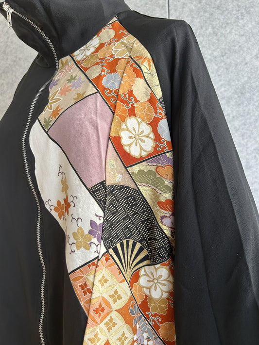 Black kimono jacket front panel with flowers and fan motifs, close-up