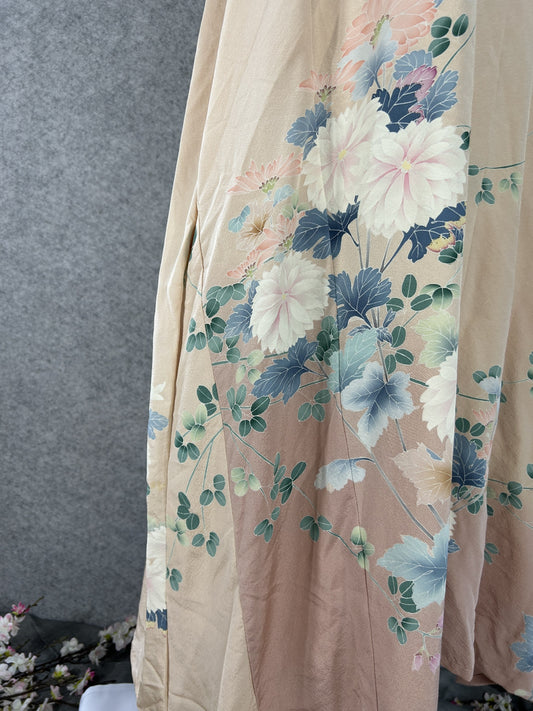 Detail of white and pink chrysanthemums with blue-grey leaves on peach silk