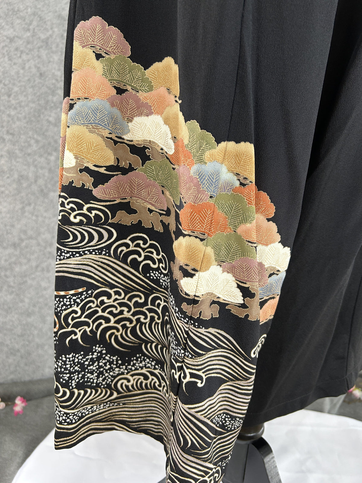 Black upcycled kimono palazzo pants, detail of the hem with tree clusters and cream waves