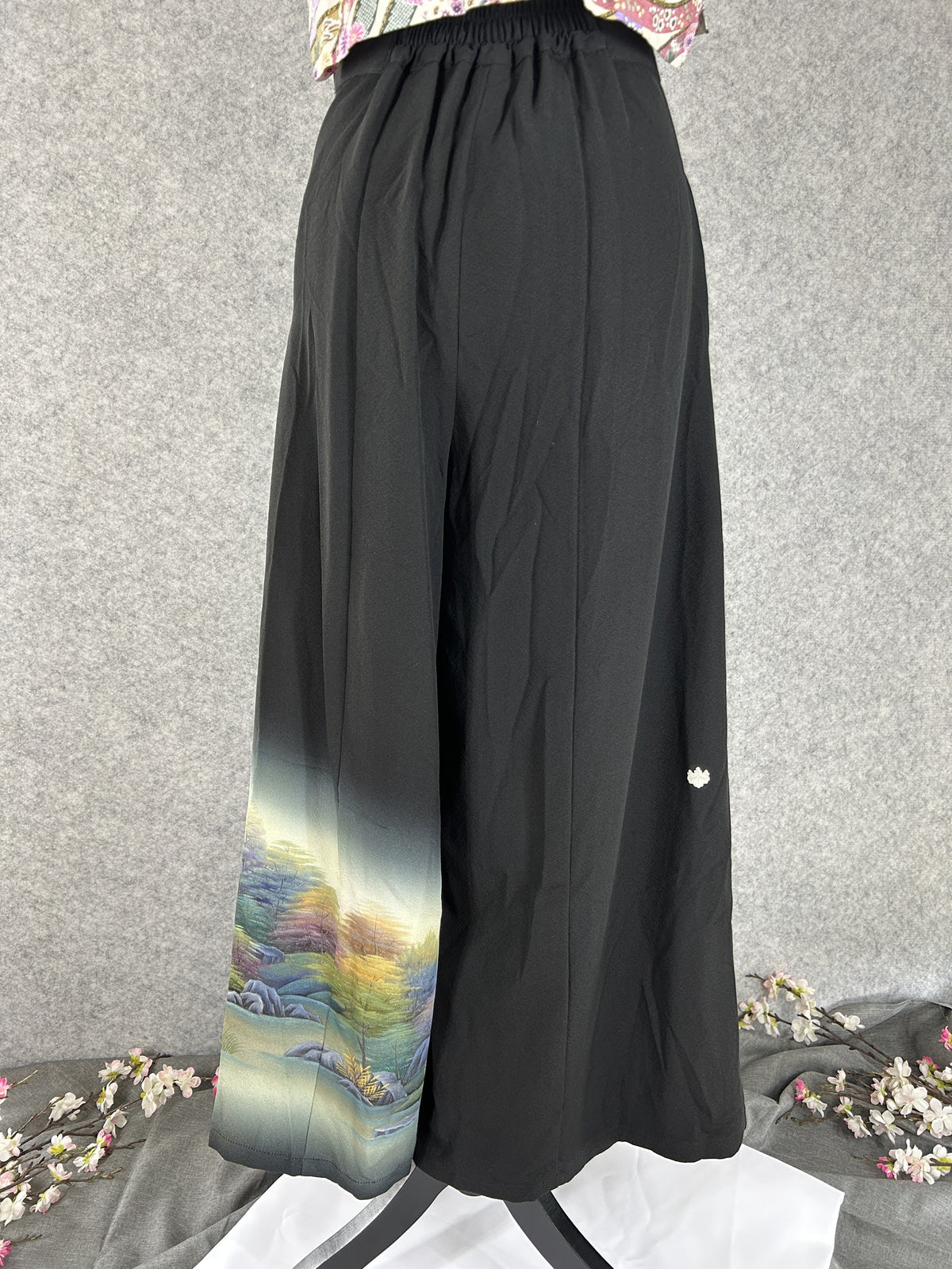 Black upcycled kimono palazzo pants with small white crest and landscape hem, back view