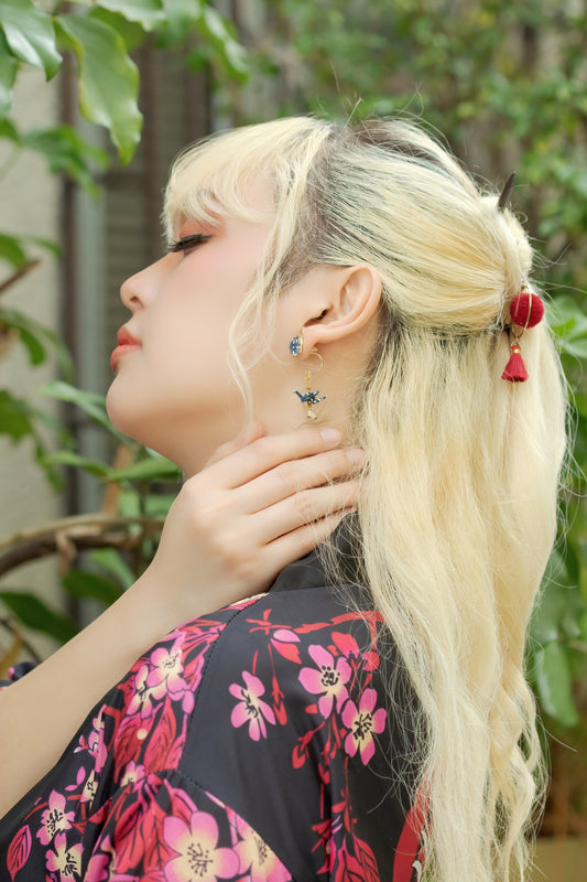 Model wearing Crane & Cabochon Origami Earrings in gold, side profile