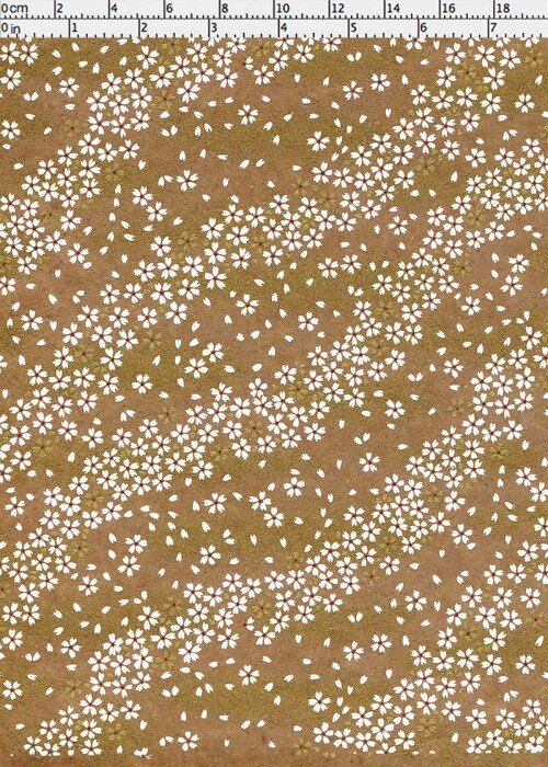 Brown chiyogami paper with small white floral pattern with a ruler for scale