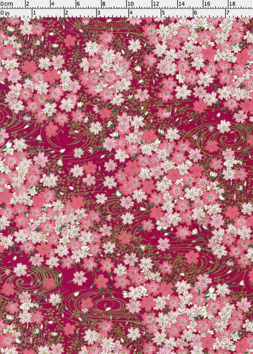 Floral pattern chiyogami paper with pink and white flowers on a red background with a ruler for scale
