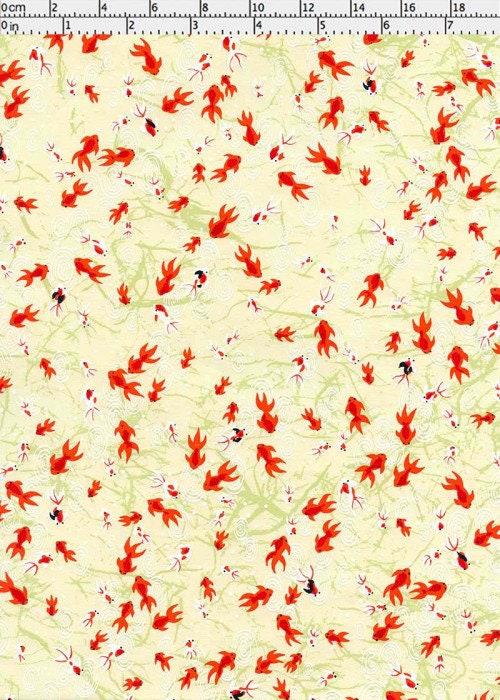 Chiyogami paper with red and black pattern on a yellow background with a ruler for scale