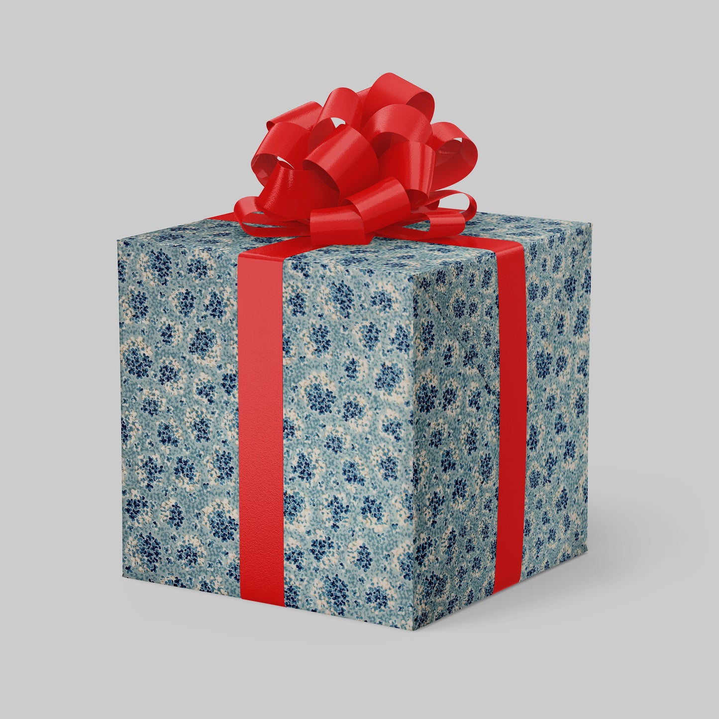Gift box wrapped with chiyogami paper with blue floral pattern and red ribbon on a gray background