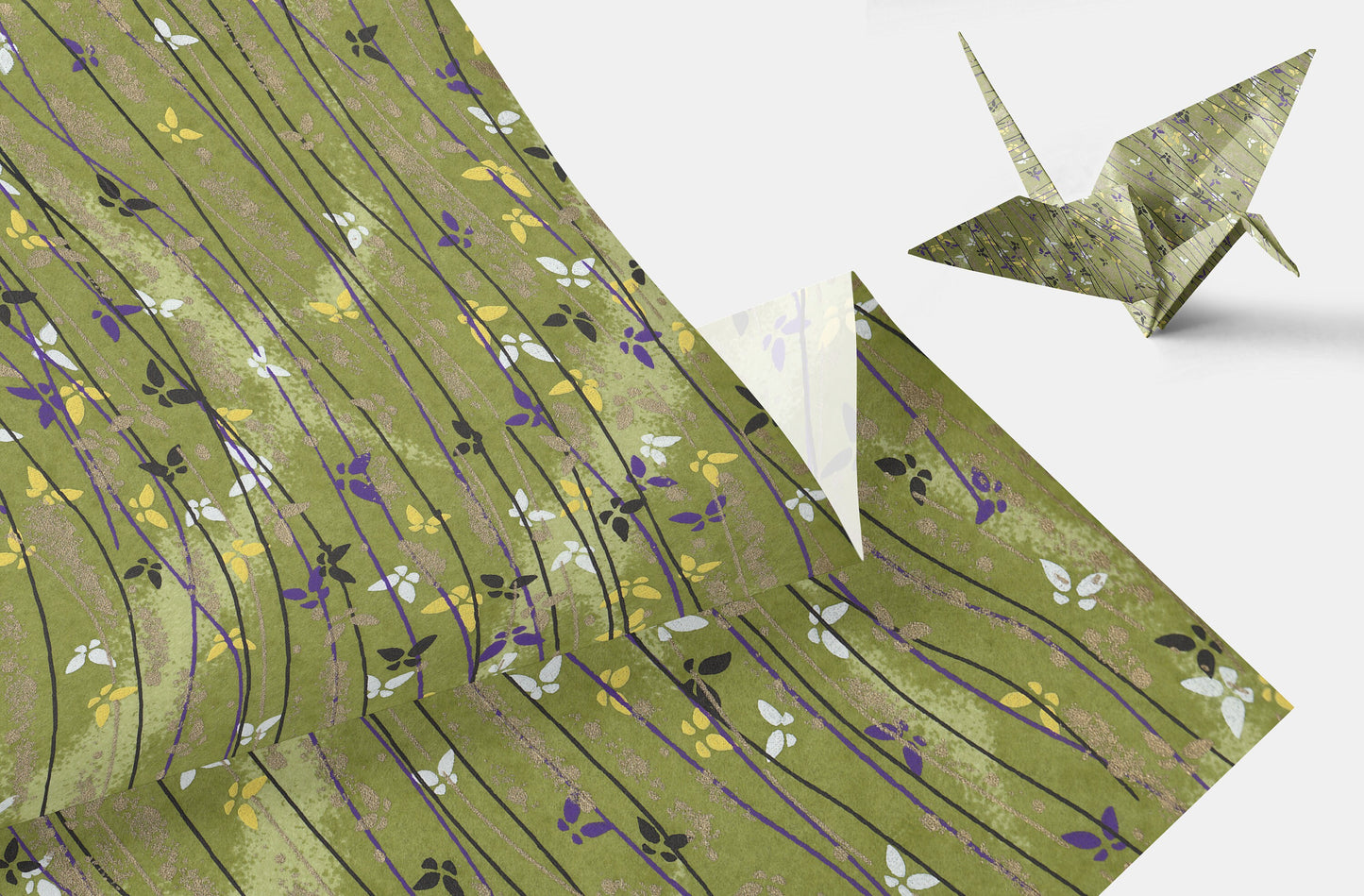 Green patterned paper with a folded paper crane on a white background