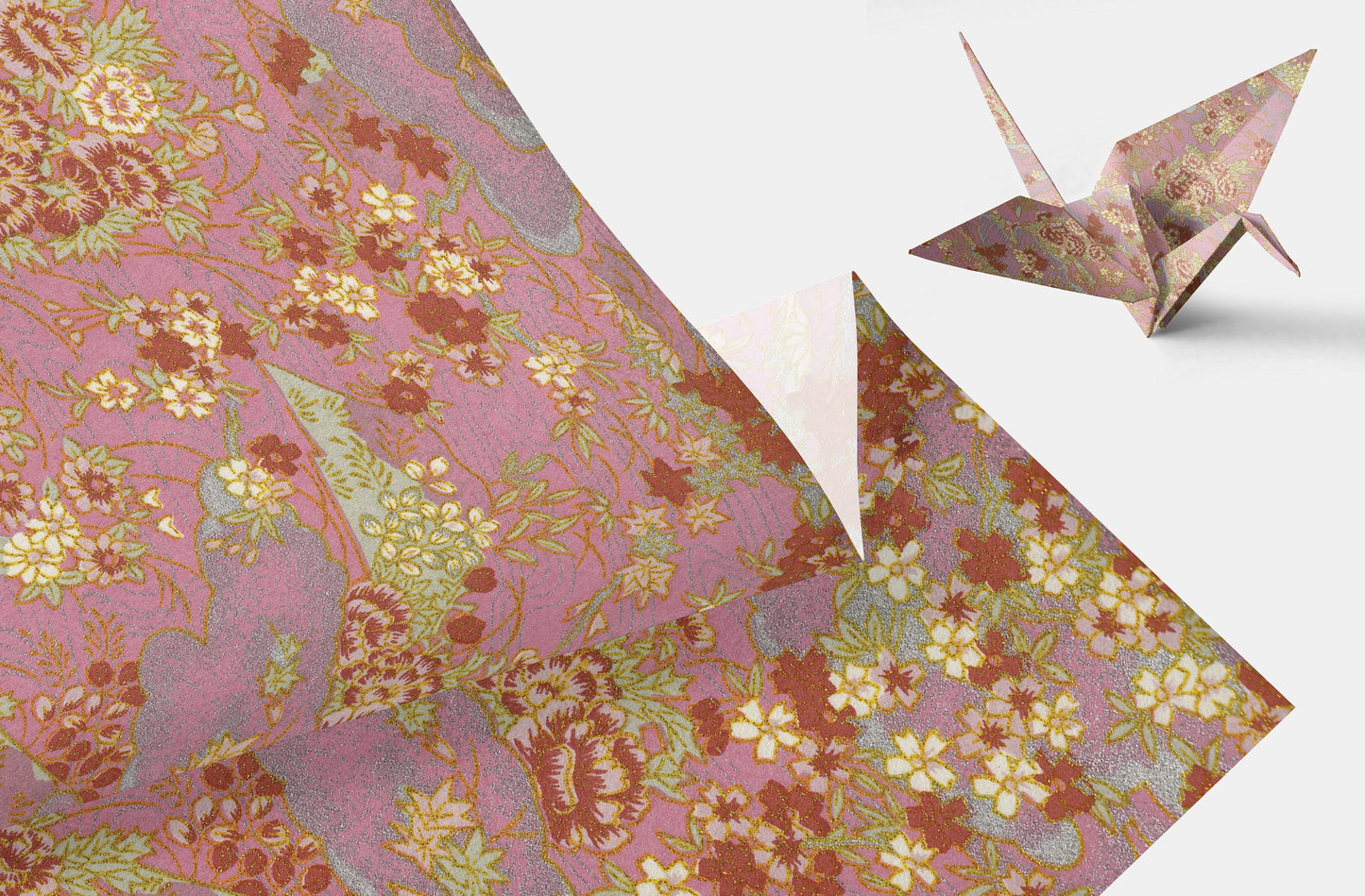 Floral-patterned chiyogami paper with a folded origami crane on a white background