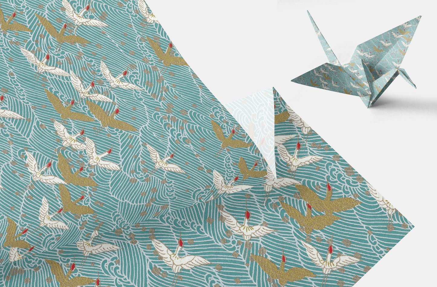 Chiyogami paper with Pattern of white and gold cranes on a teal background and a folded paper crane on a white background