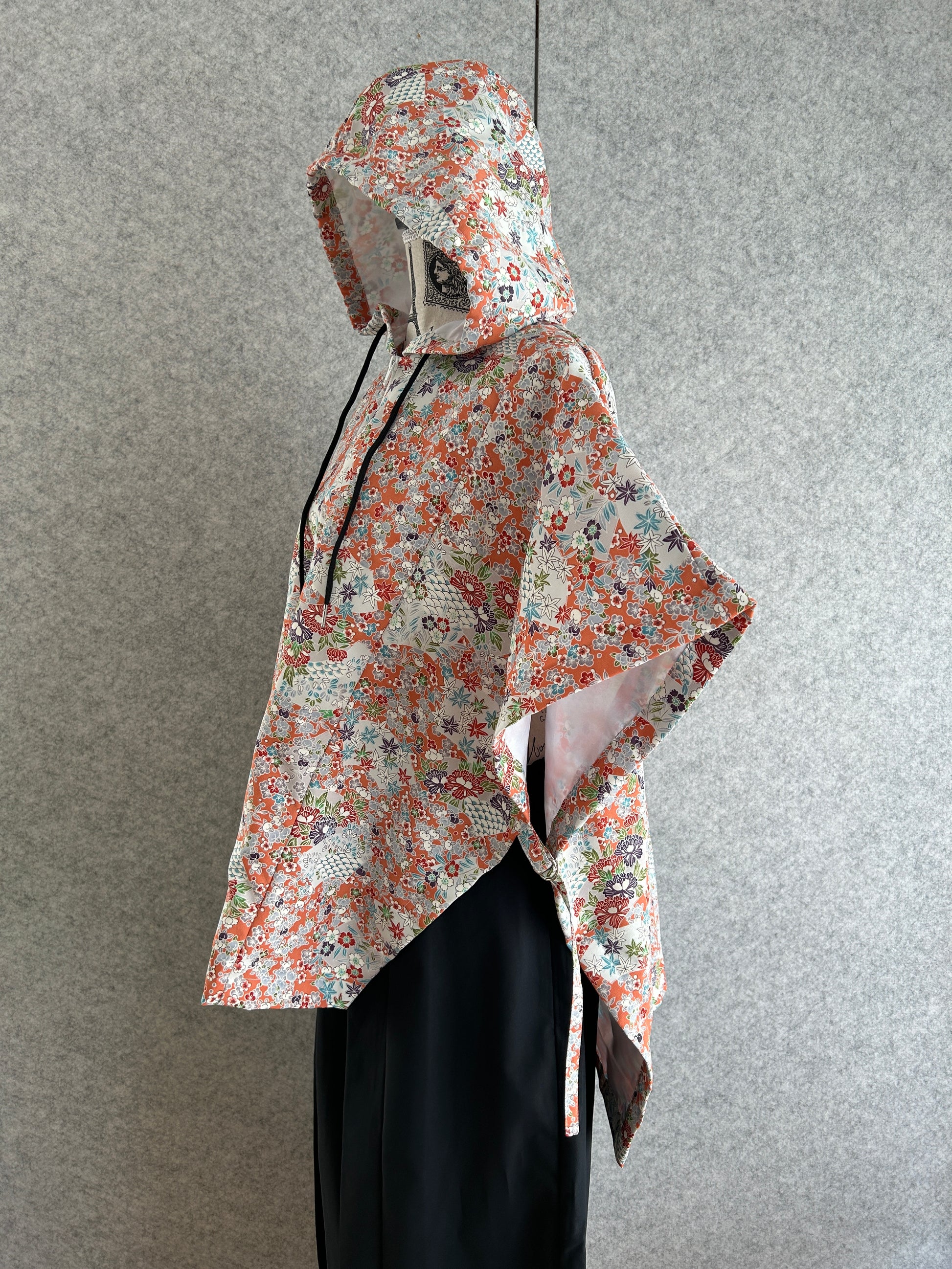 Floral-patterned dress on a mannequin against a gray background