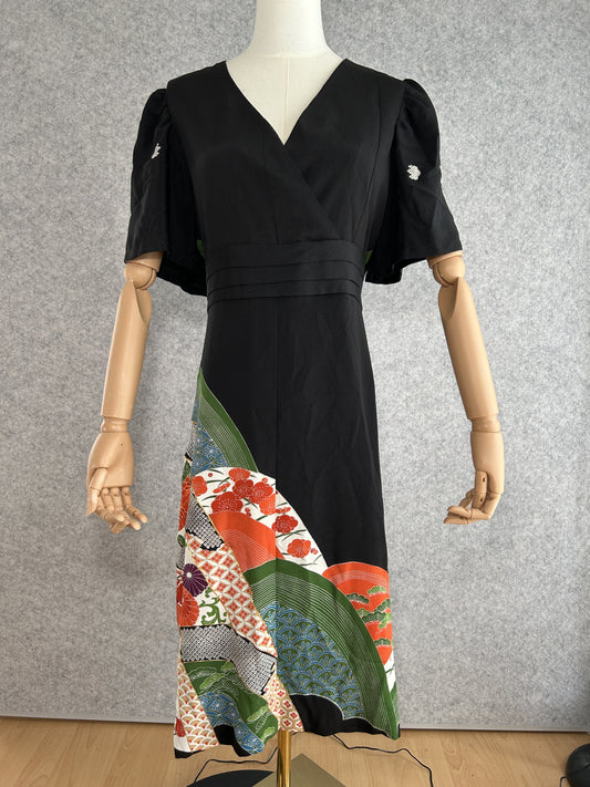 Black empire cut kimono dress with puff sleeves and colourful patterned hem, front view