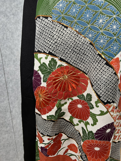 Close-up of chrysanthemums and blue flower pattern with gold outlines on black dress