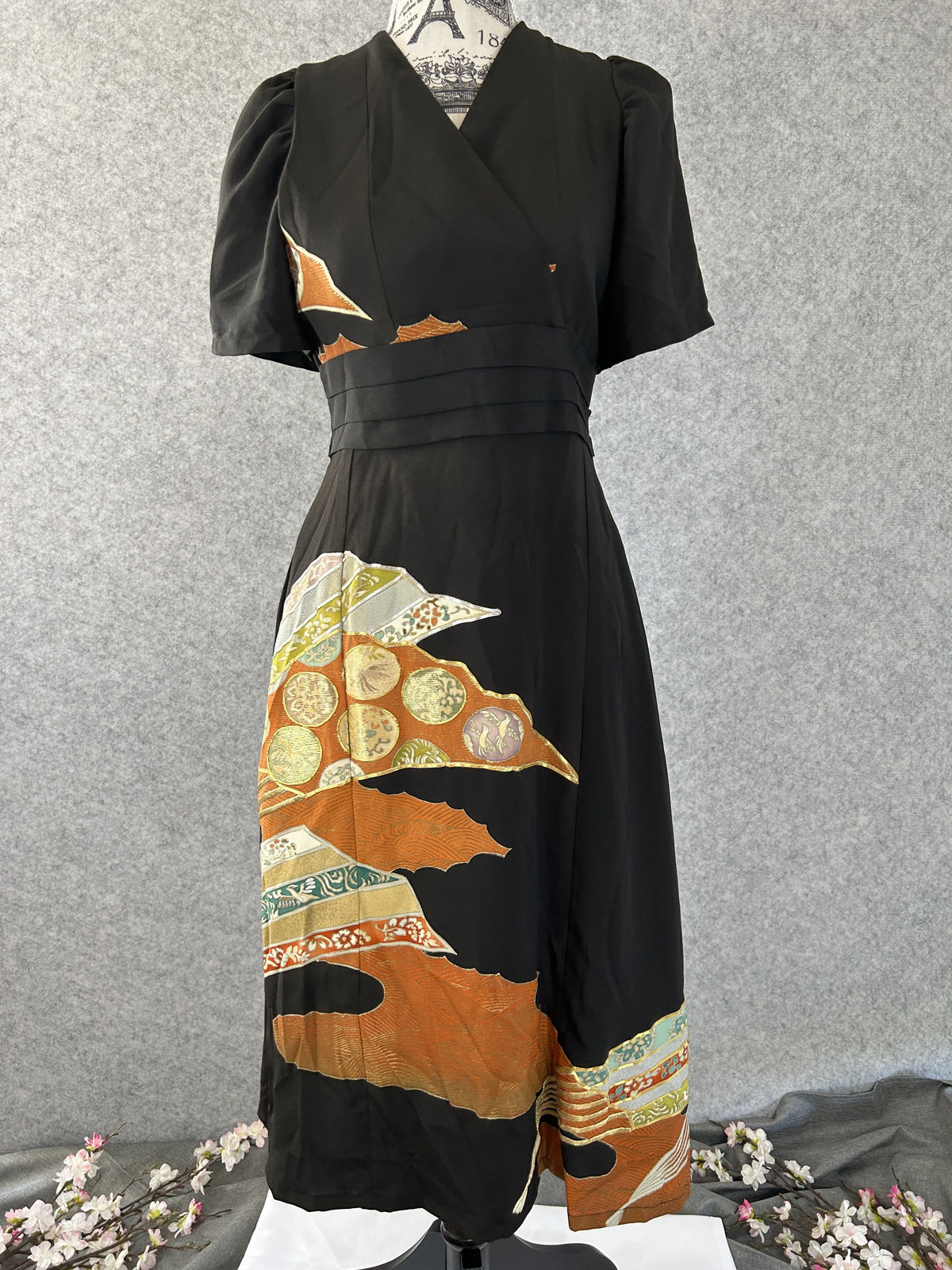 Black empire cut kimono dress with puff sleeves and orange gold design, front view