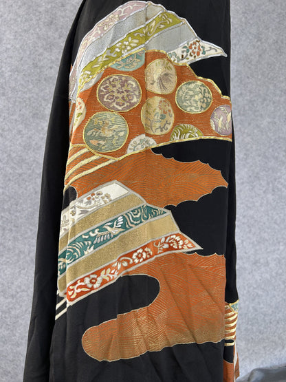 Detail of orange clouds and roundels with gold outlines on black kimono silk