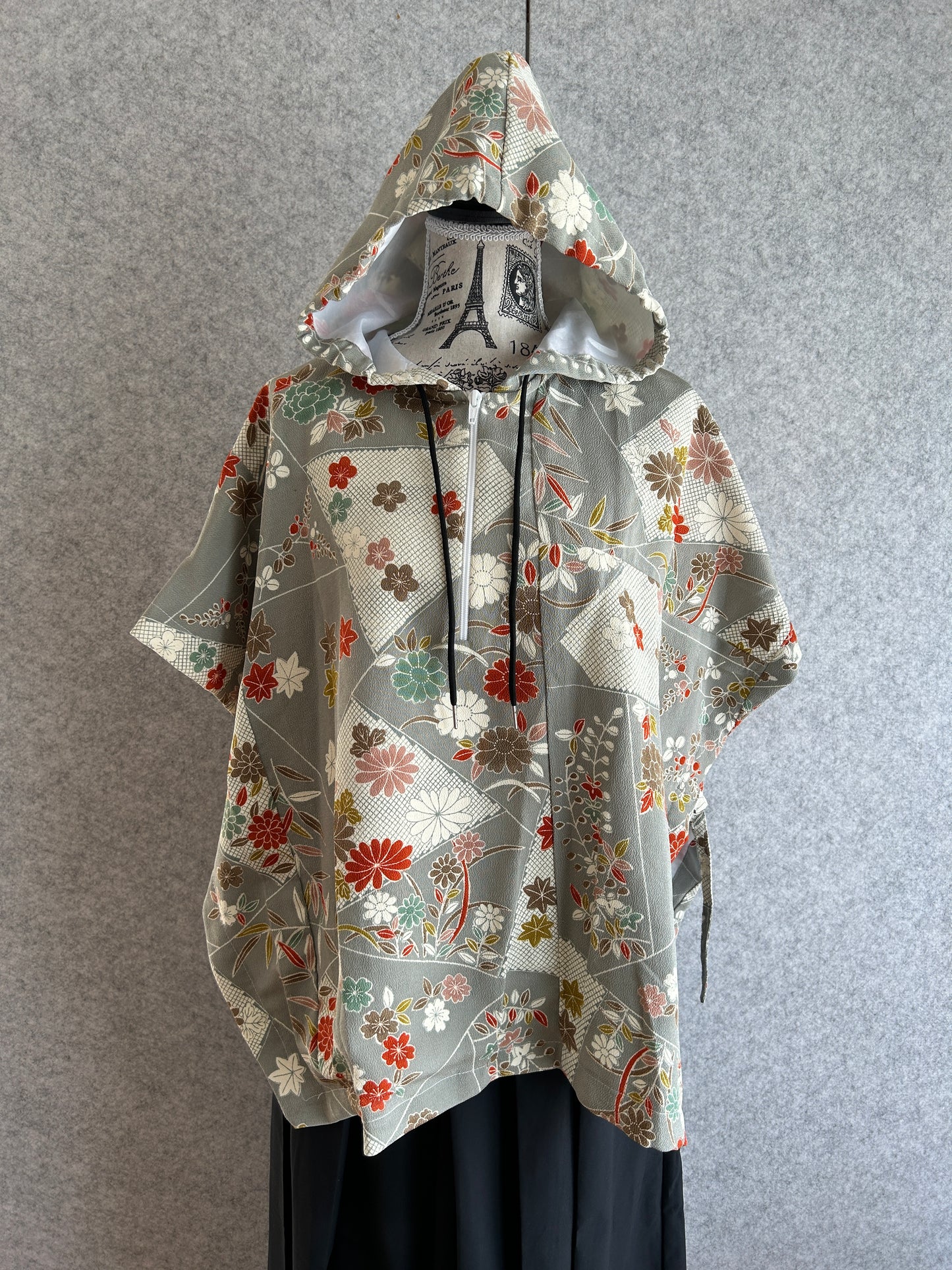Floral-patterned umbrella folded and placed on a gray surface