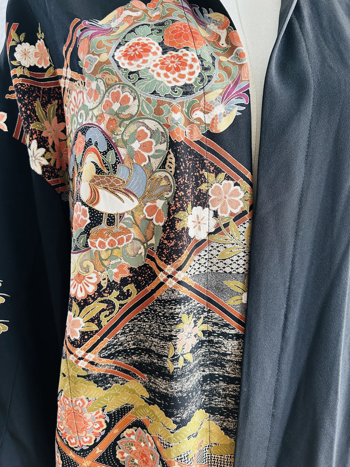 Black kimono hoodie, detail of floral medallion with ducks and lattice bands
