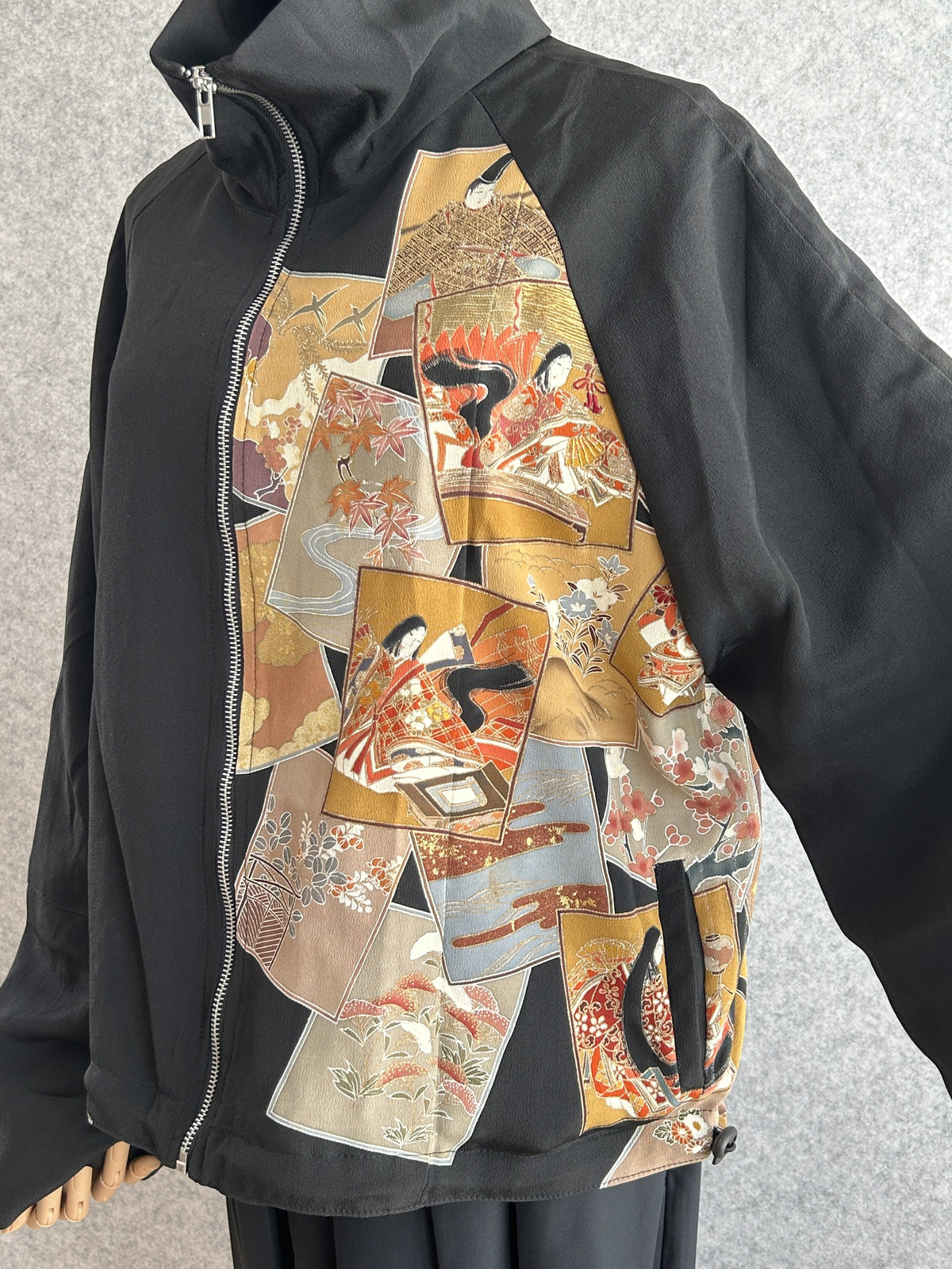 Black high collar kimono jacket, angled front detail of picture card panel