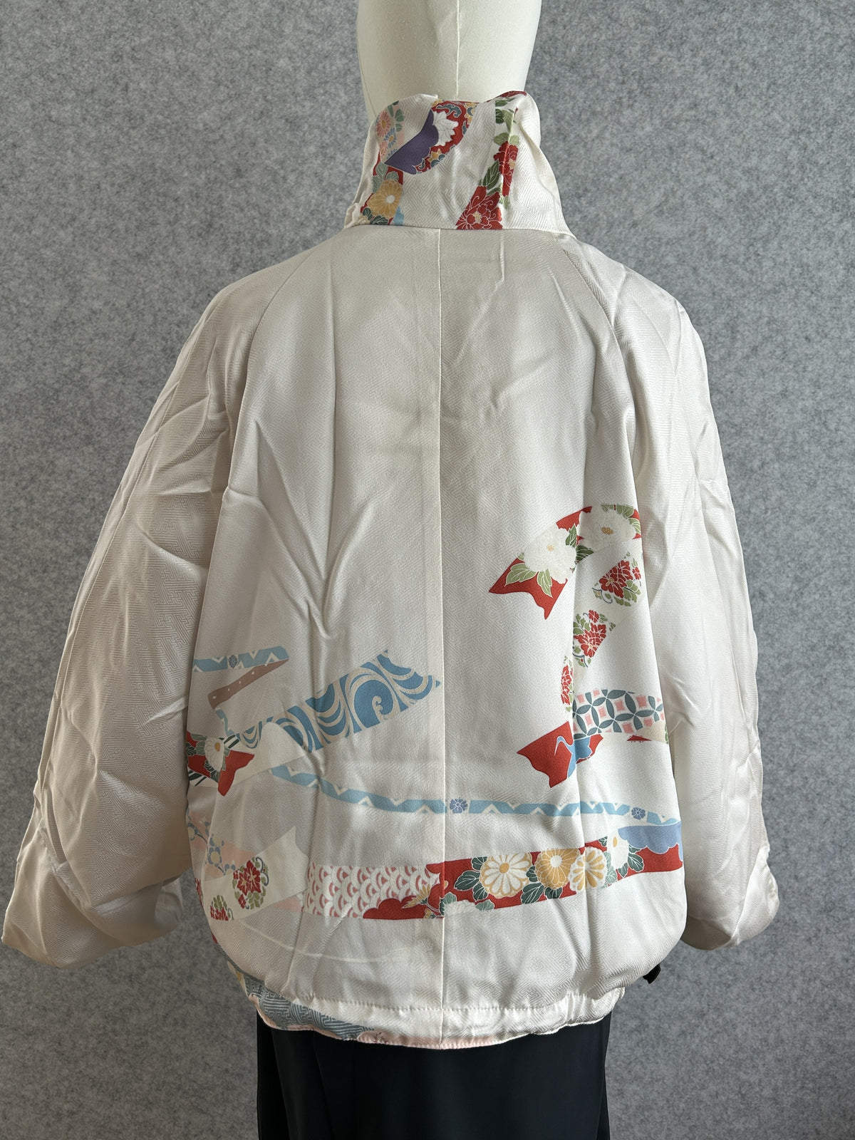 White high collar kimono jacket with red and blue ribbon bands, back view