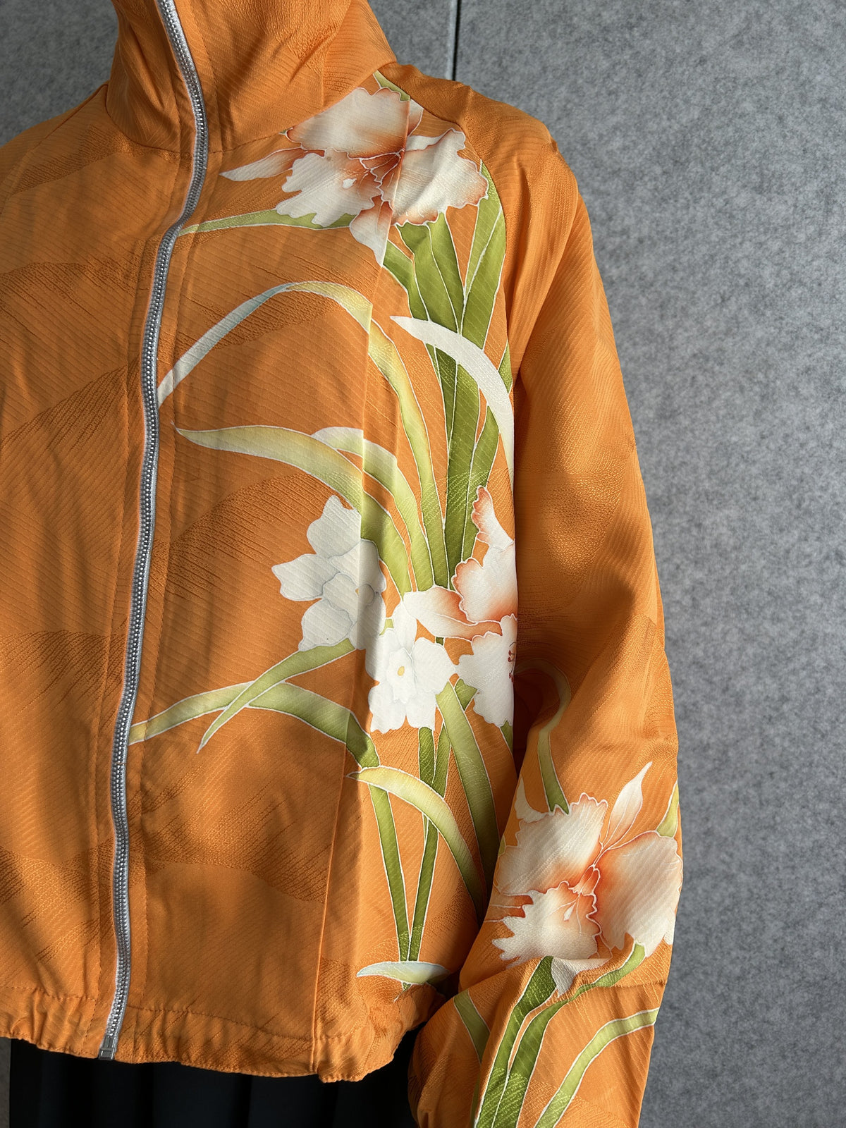 Orange high collar kimono jacket, detail of white flowers and green leaves
