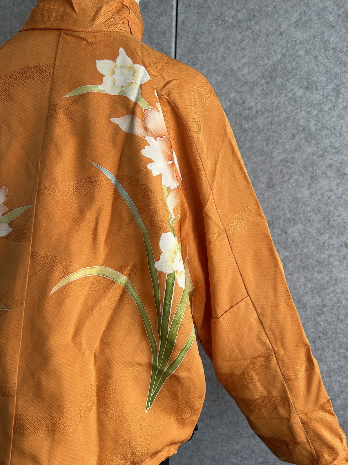 Orange high collar kimono jacket, detail of white flowers on back shoulder
