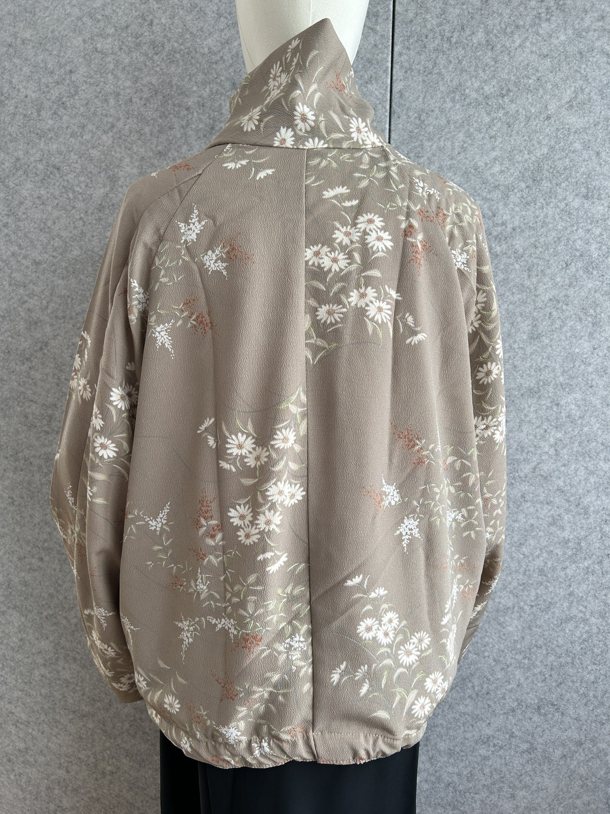Taupe high collar kimono jacket with small white flower pattern, back view
