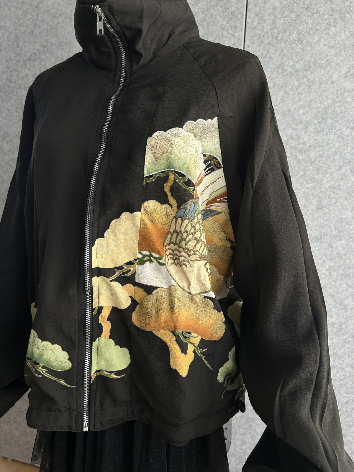 Black high collar kimono jacket with pine motifs, angled front view showing zipper and bird motif