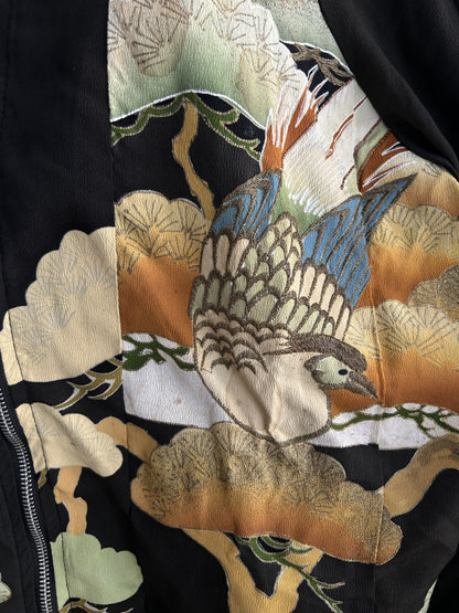 Black high collar kimono jacket with pine motifs, detail of the bird among pine motifs