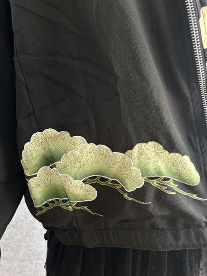 Black high collar kimono jacket with pine motifs, detail of green pine motif at the front hem