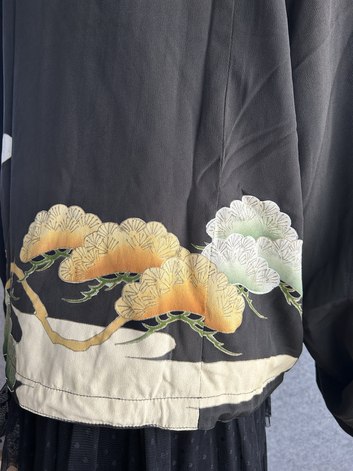 Black high collar kimono jacket with pine motifs, detail of orange and white pine motifs on the back