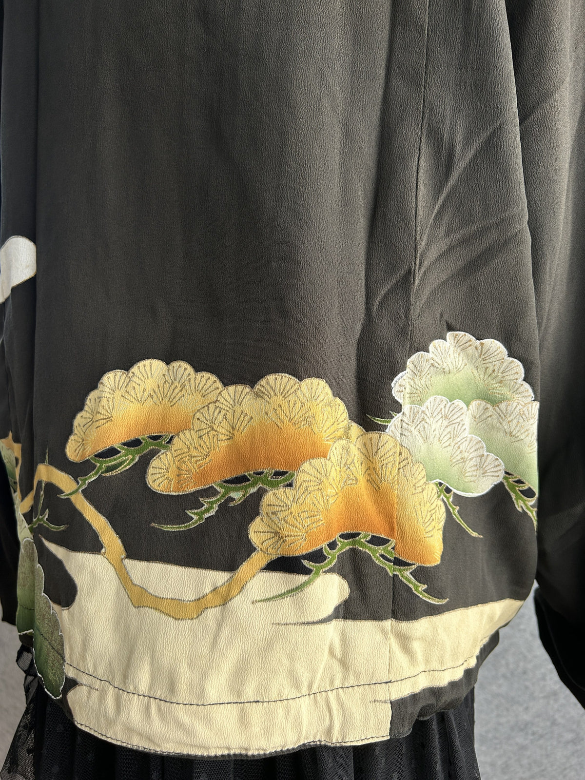 Black high collar kimono jacket with pine motifs, detail of cream band at the back hem