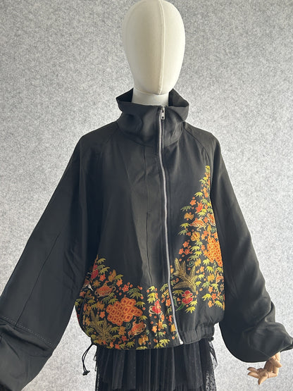 Black high collar kimono jacket with floral band, angled front view
