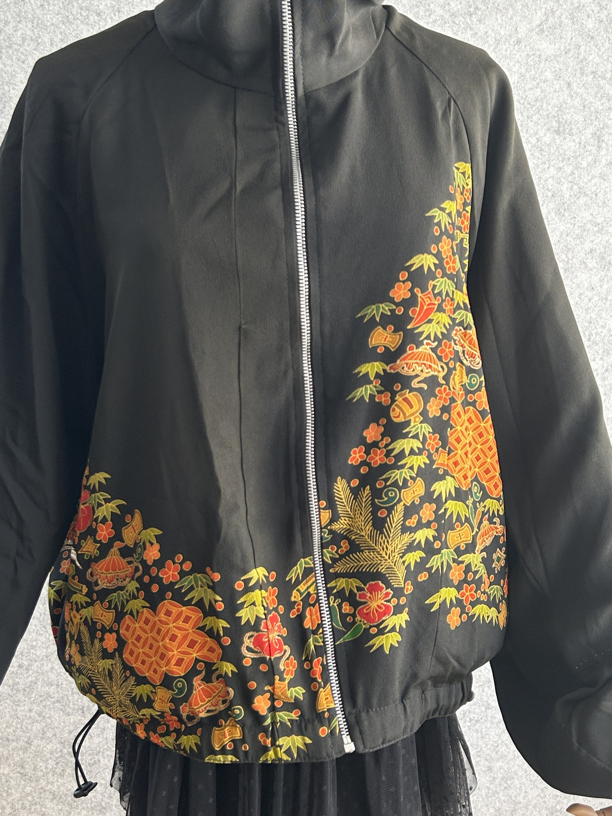 Black high collar kimono jacket with floral band, closer front view showing zipper and floral band