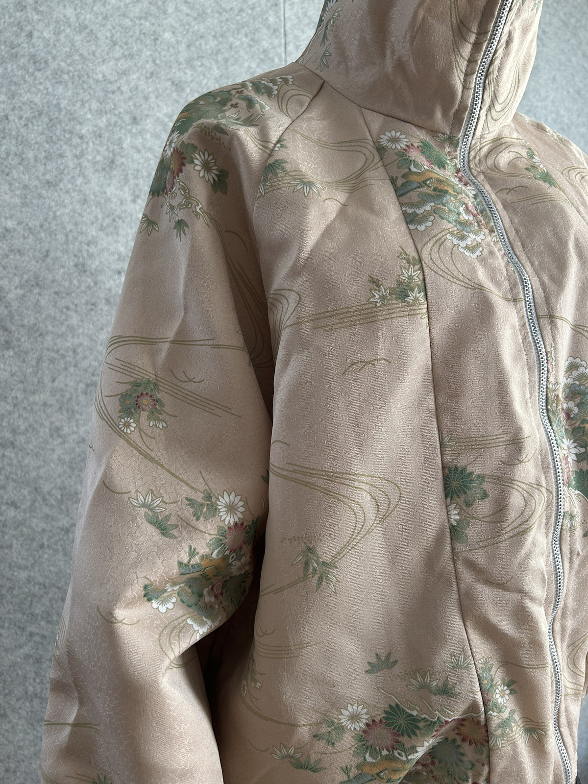 Pale beige pink high collar kimono jacket with flowers, angled front view of shoulder and collar