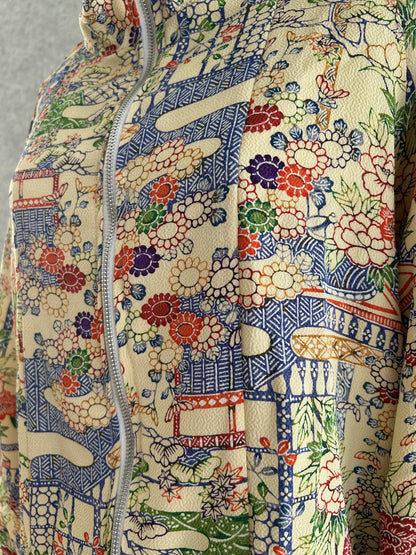 Cream high collar kimono jacket with colourful flowers, detail of the front with zipper and flowers