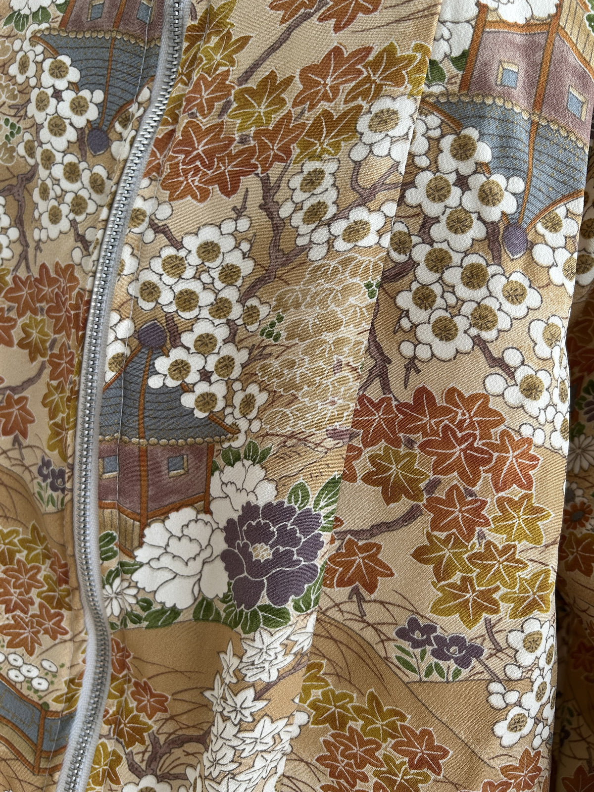 Golden beige high collar kimono jacket with blossoms, detail of blossoms and maple leaves by the zipper