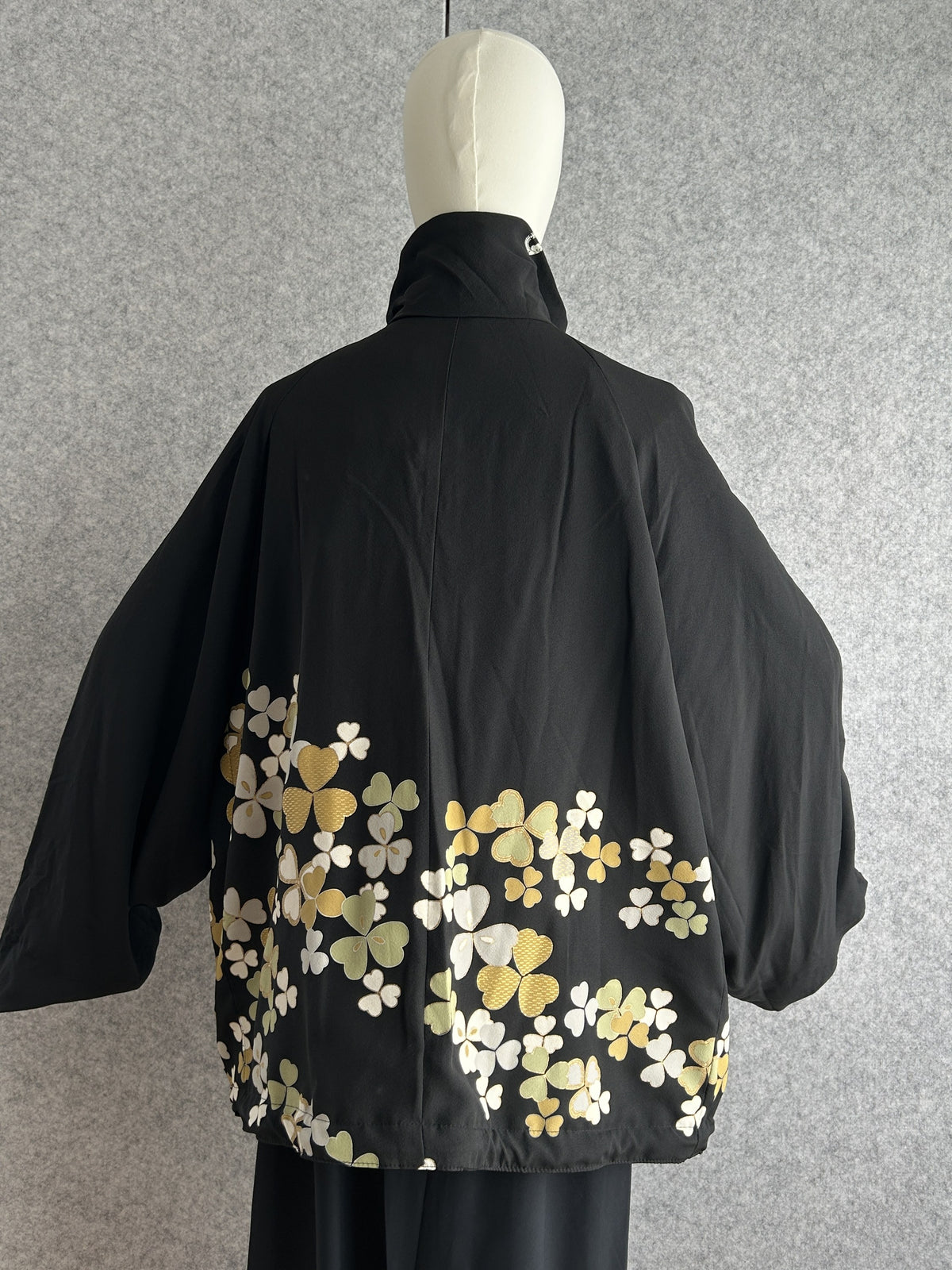 Black high collar kimono jacket with clover leaves, back view