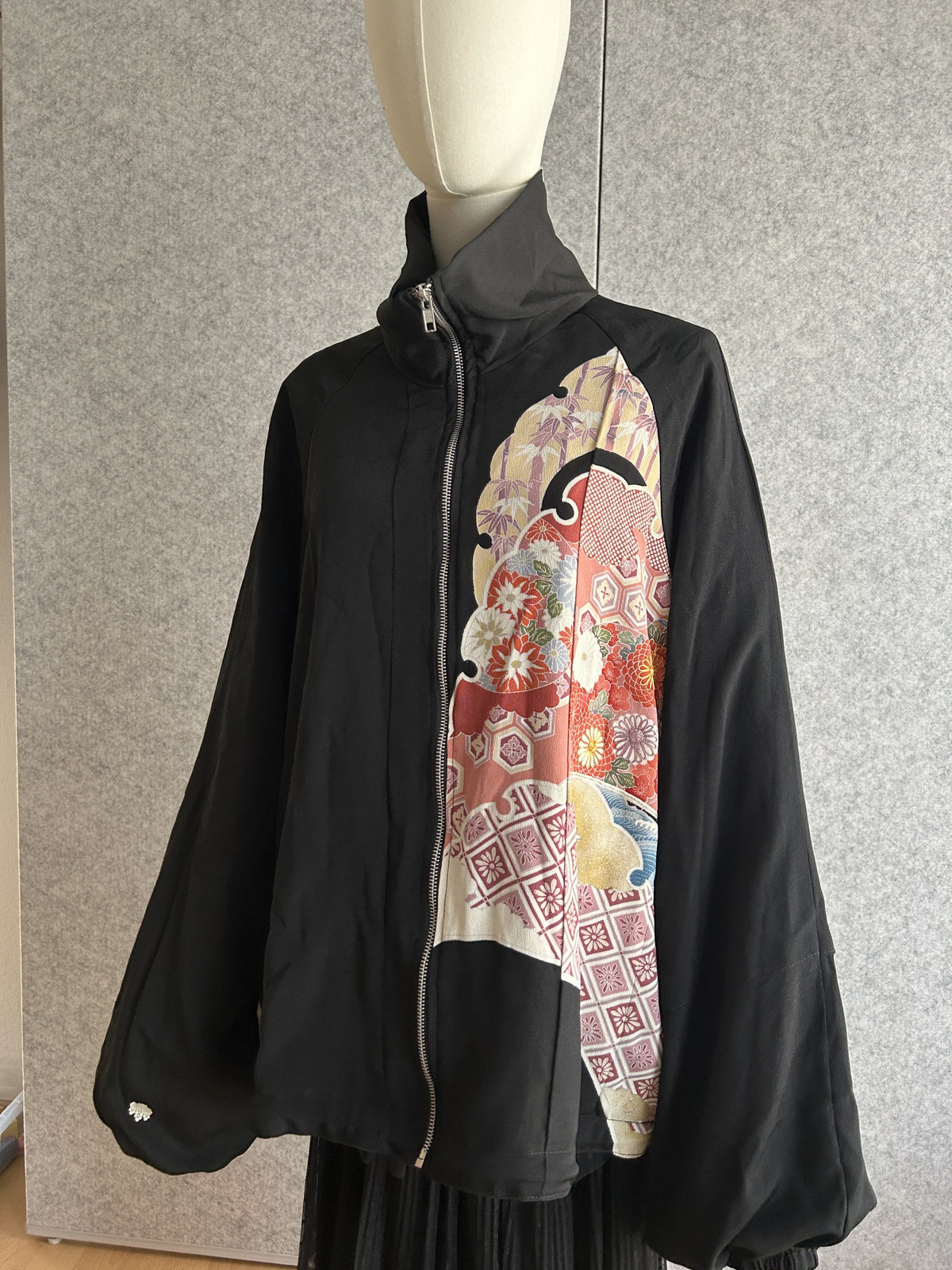 Black high collar kimono jacket with colourful floral panel, front view