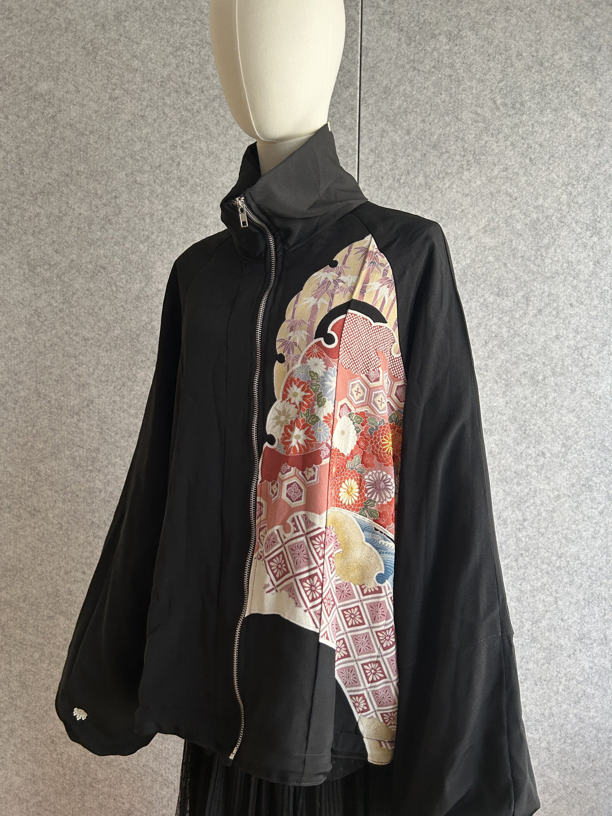 Black kimono jacket with floral and geometric front panel, angled front view