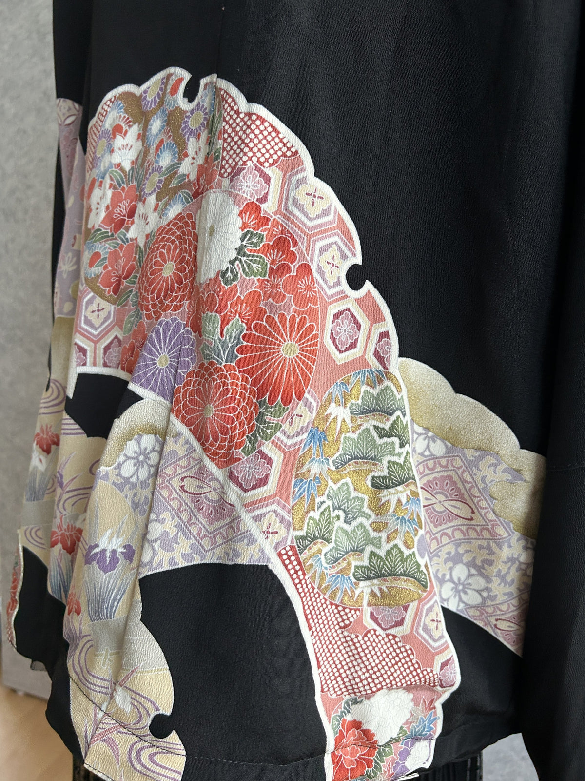 Black kimono jacket, detail of chrysanthemums and pine motif on back hem