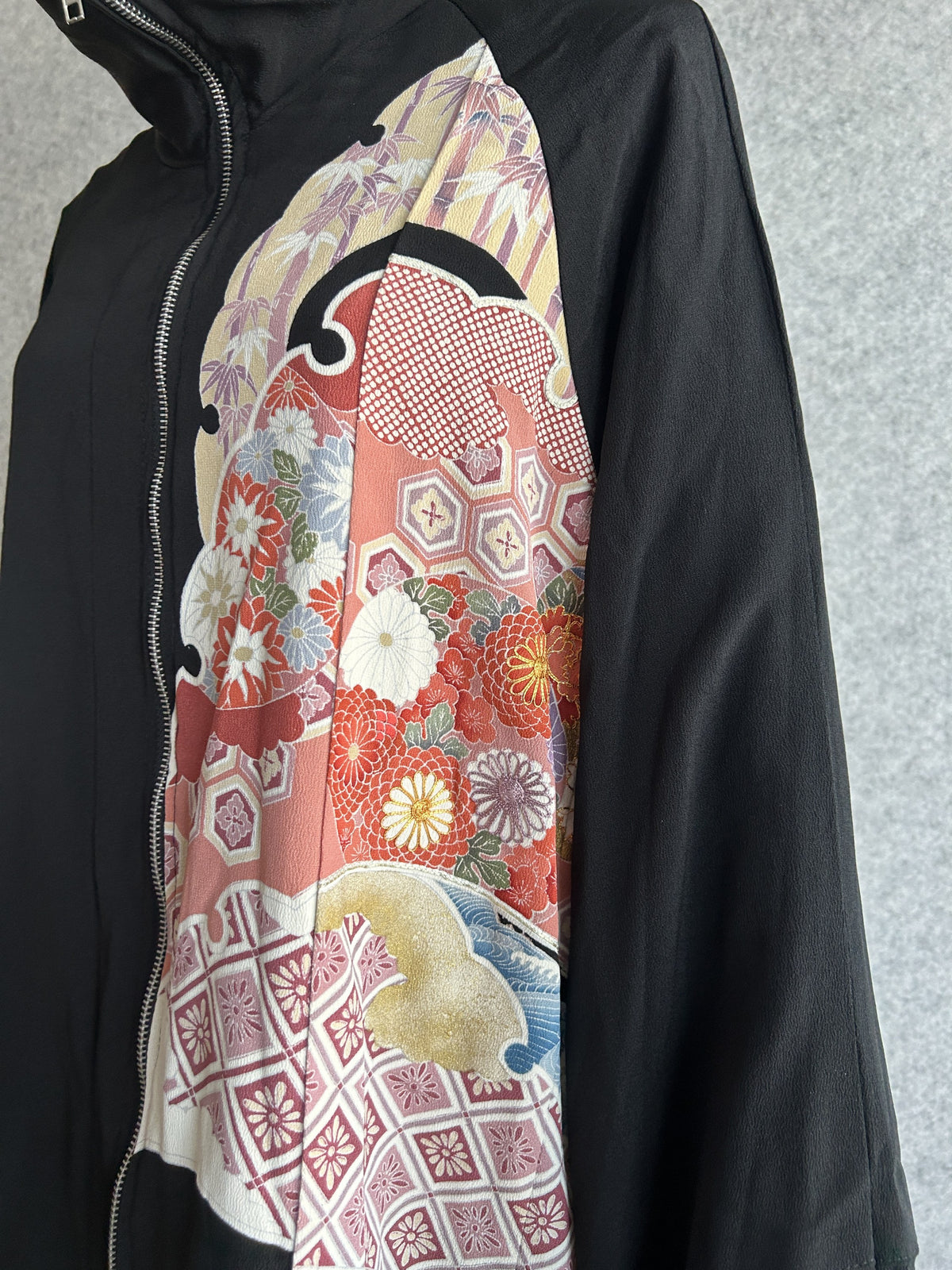 Black kimono jacket, close-up of front panel with red flowers and zipper