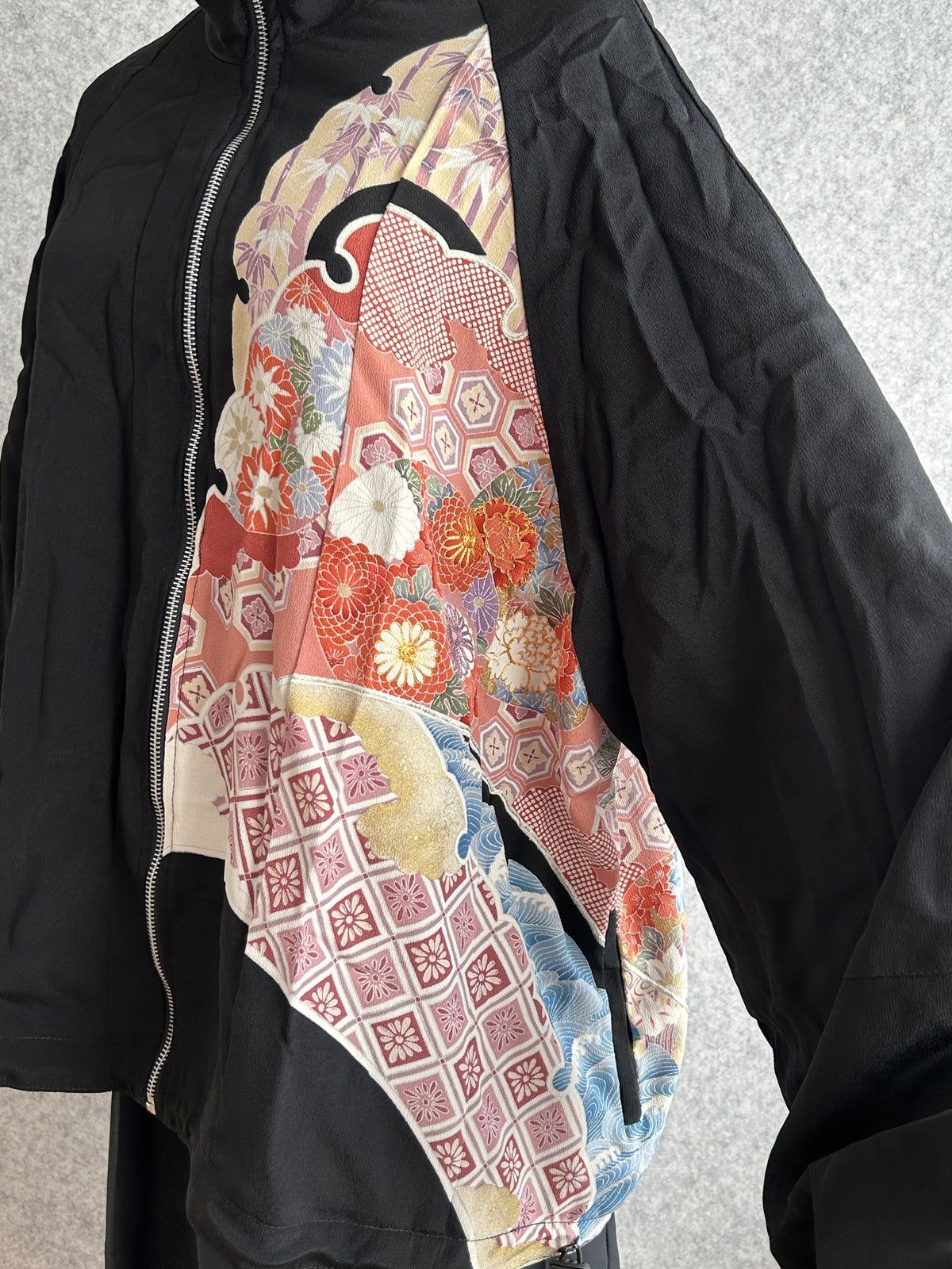 Black kimono jacket, detail of front floral panel and wide sleeve