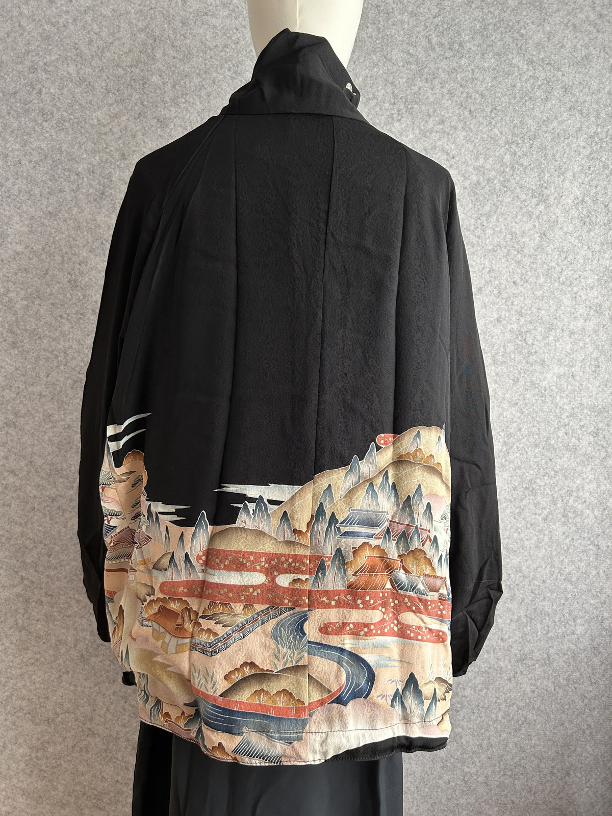 Black high collar kimono jacket with landscape scene at hem, back view