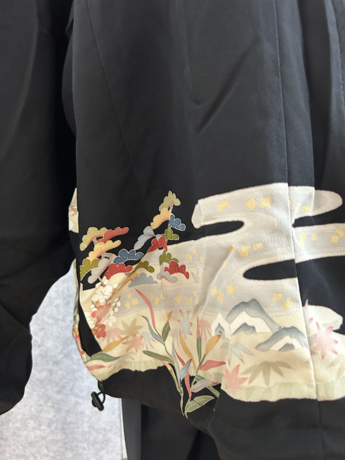 Black kimono jacket, detail of sleeve with cream cloud and pine motif