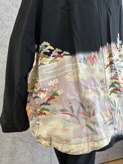 Black kimono jacket, detail of pastel landscape on back hem, side angle