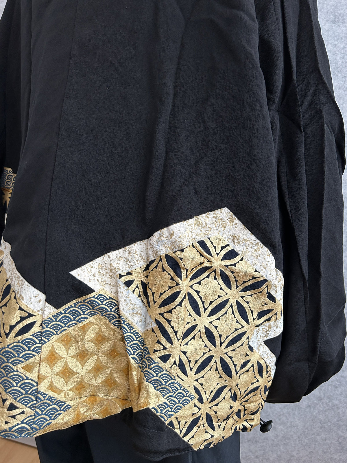 Black kimono jacket, close-up of gold and navy geometric panel on back
