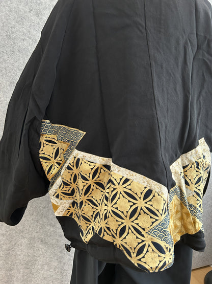 Black kimono jacket, detail of gold geometric hem panel, side view