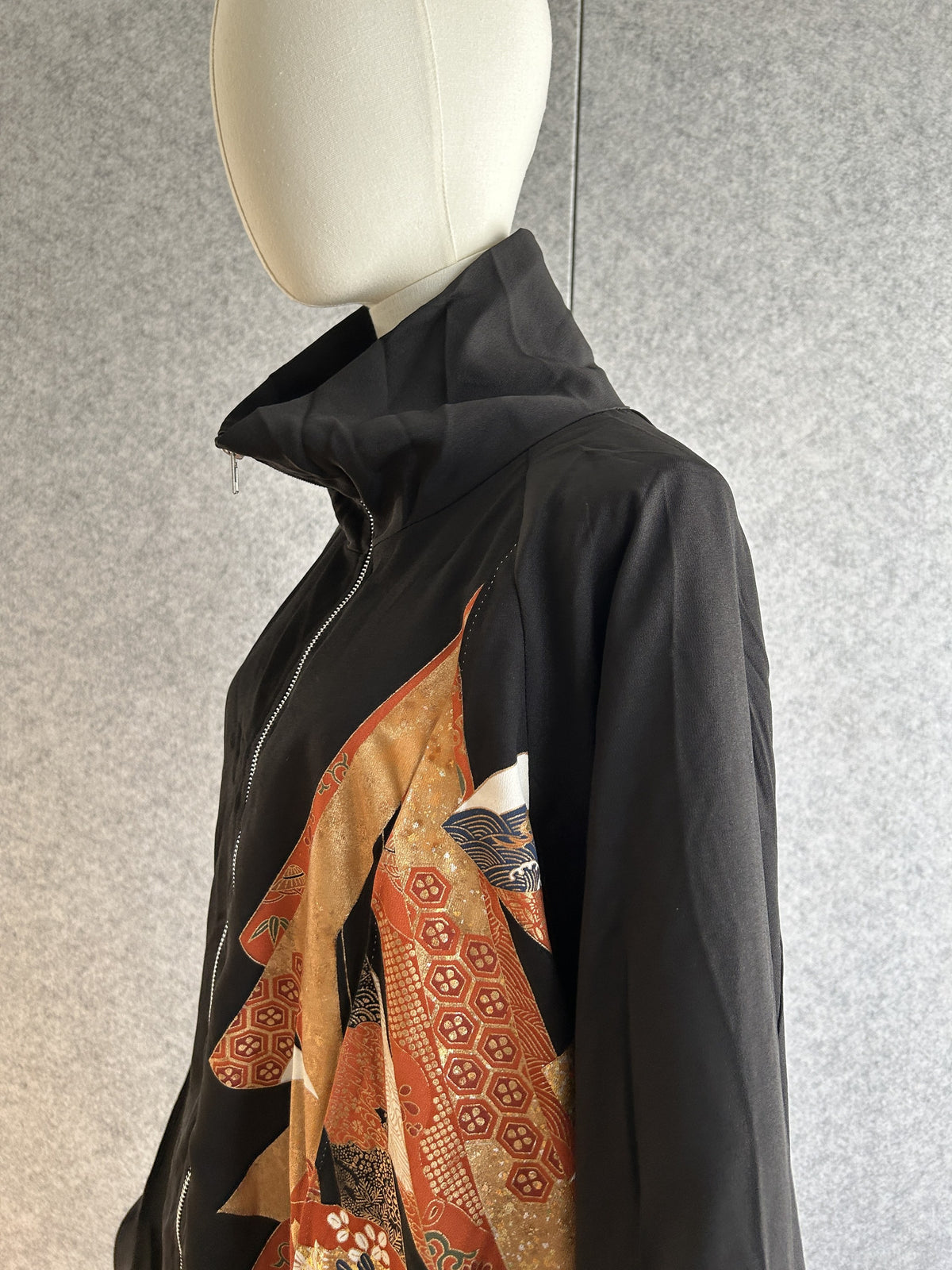 Black kimono jacket, detail of high collar and orange front panel, side view