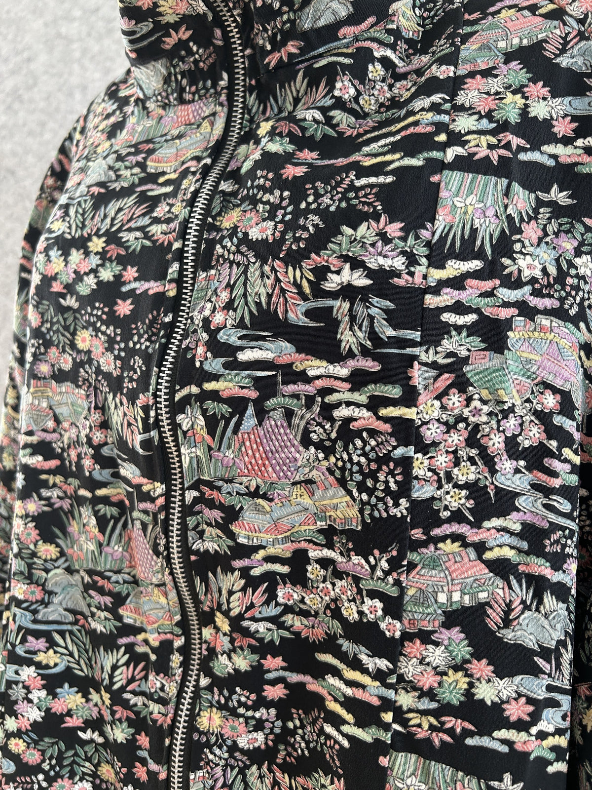 Black kimono jacket, close-up of small houses and flowers pattern by zipper