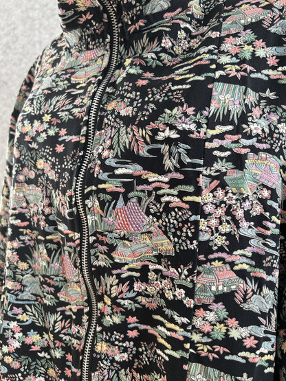 Black kimono jacket, close-up of small houses and flowers pattern by zipper