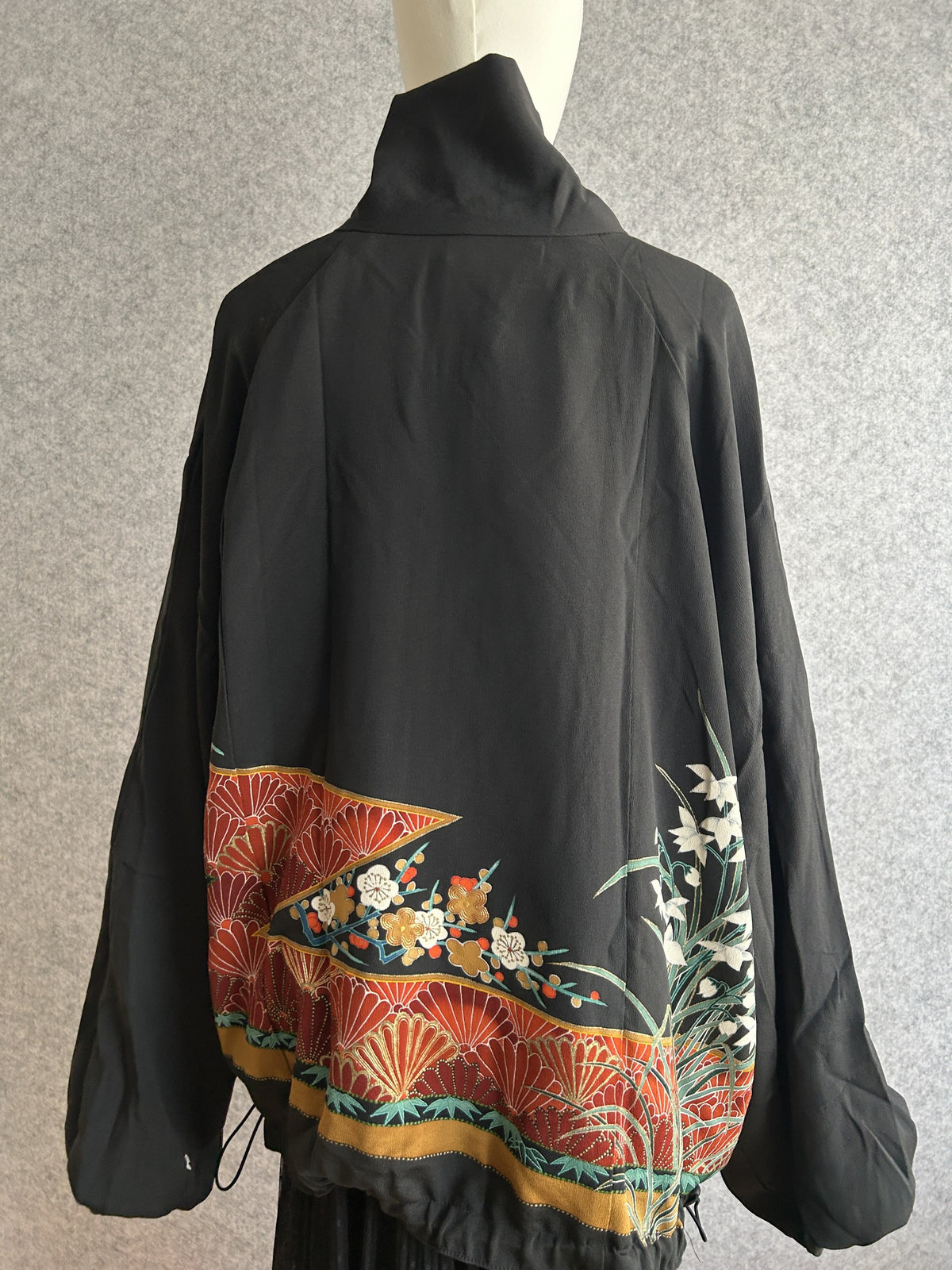 Black high collar kimono jacket with red patterned hem, back view
